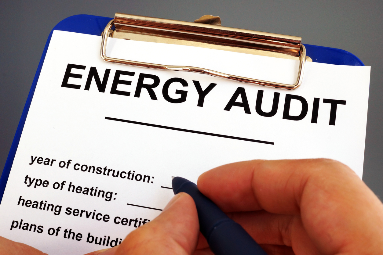 Man filling in energy audit form in a clipboard