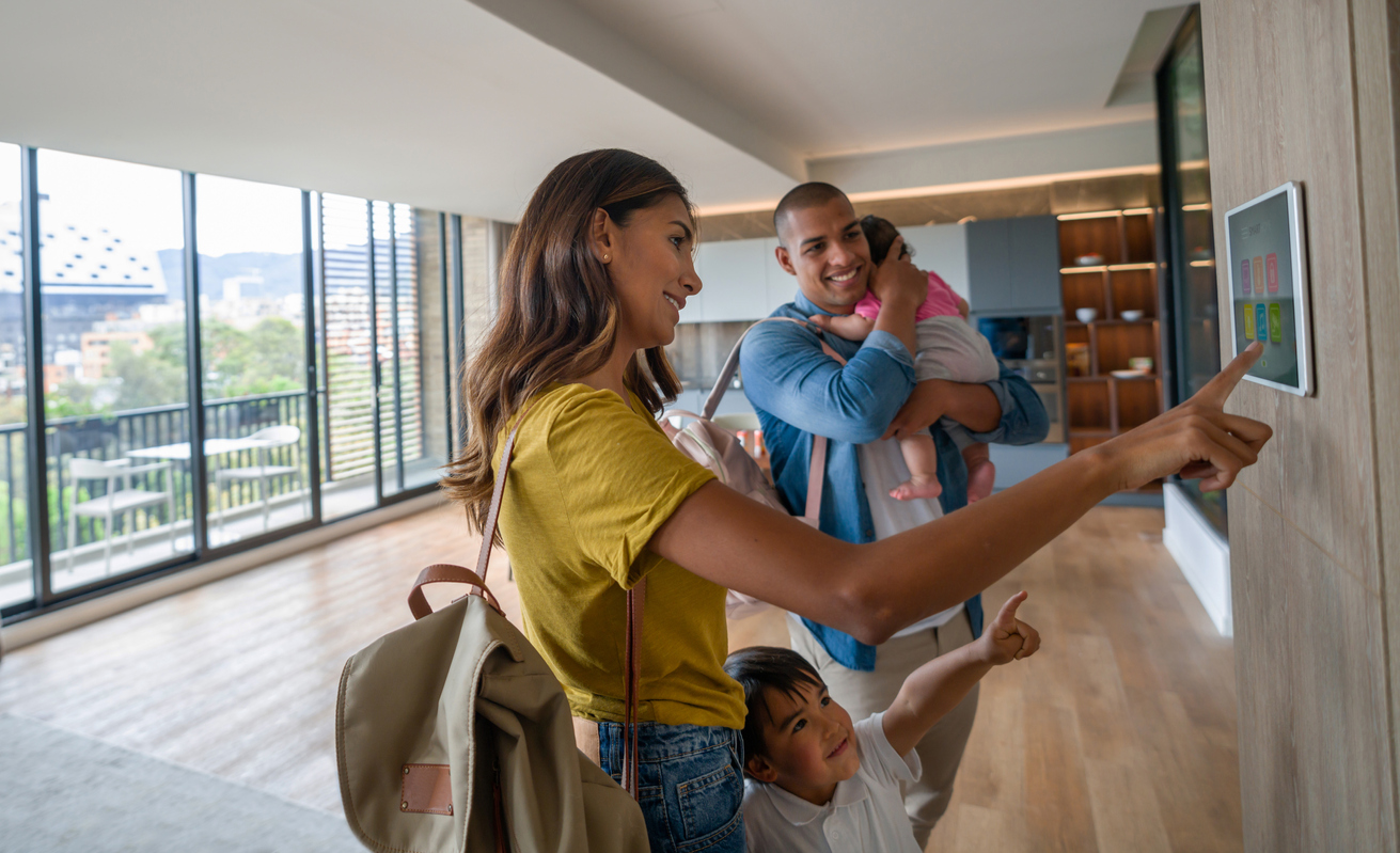 Happy family leaving the house locking the door using automated security system