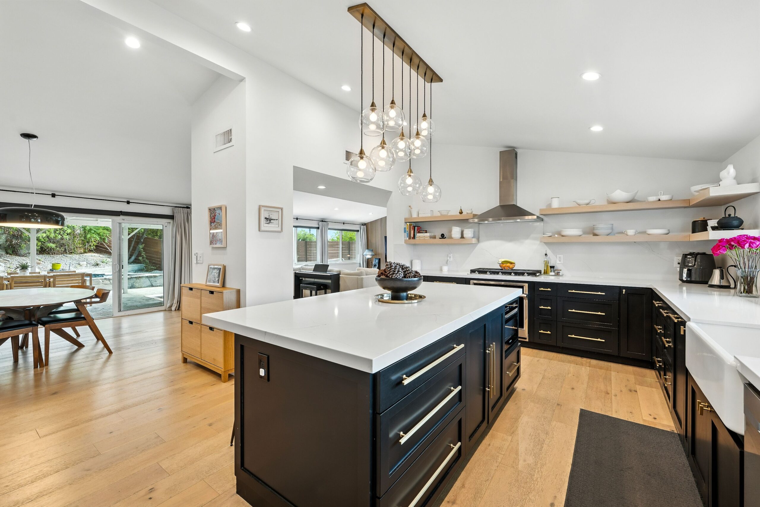 Bright open concept kitchen with a white island, pendant lighting, and an open sightline through to the dining area